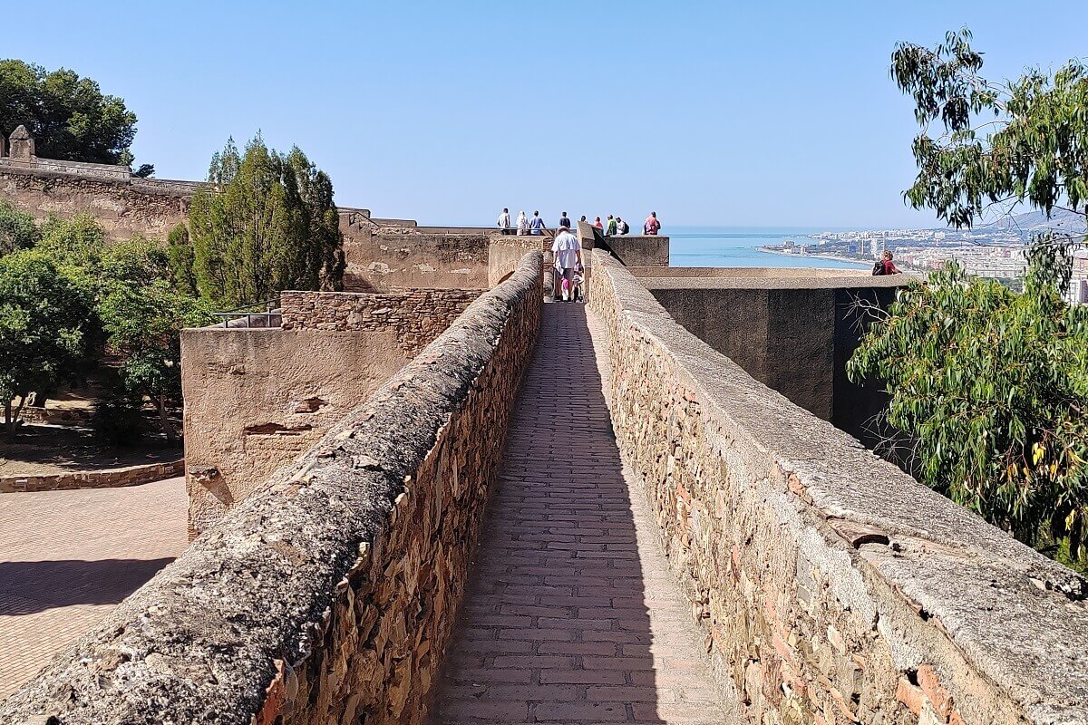 Séta a malagai Gibralfaro-vár (Castillo de Gibralfaro) történelmi várfalán. Malaga látnivalók és kilátás a Földközi-tengerre.