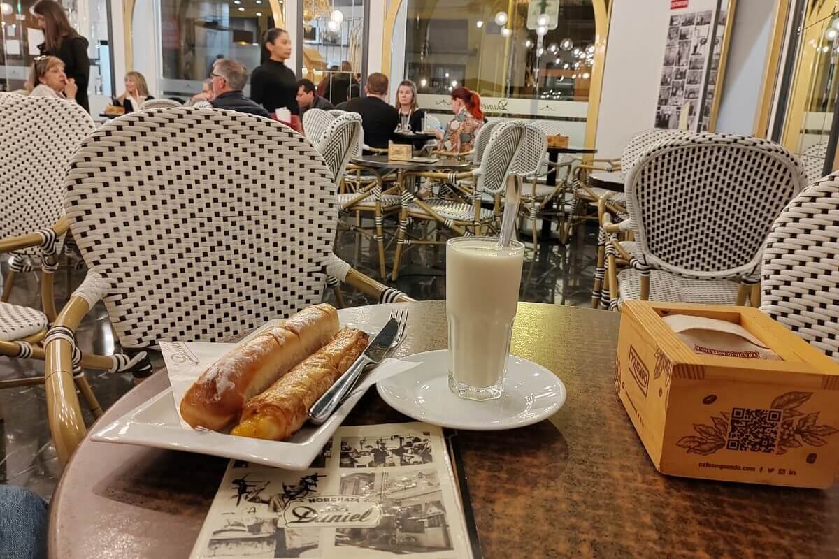 Hagyományos valenciai horchata és fartons sütemény egy helyi horchateríában. Valenciai gasztronómia és látnivalók.
