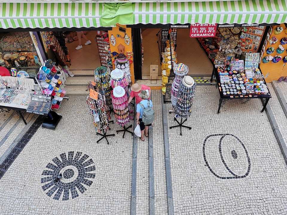 macskaköves utca felülről, ajándékbolttal és vásárló turistkkal